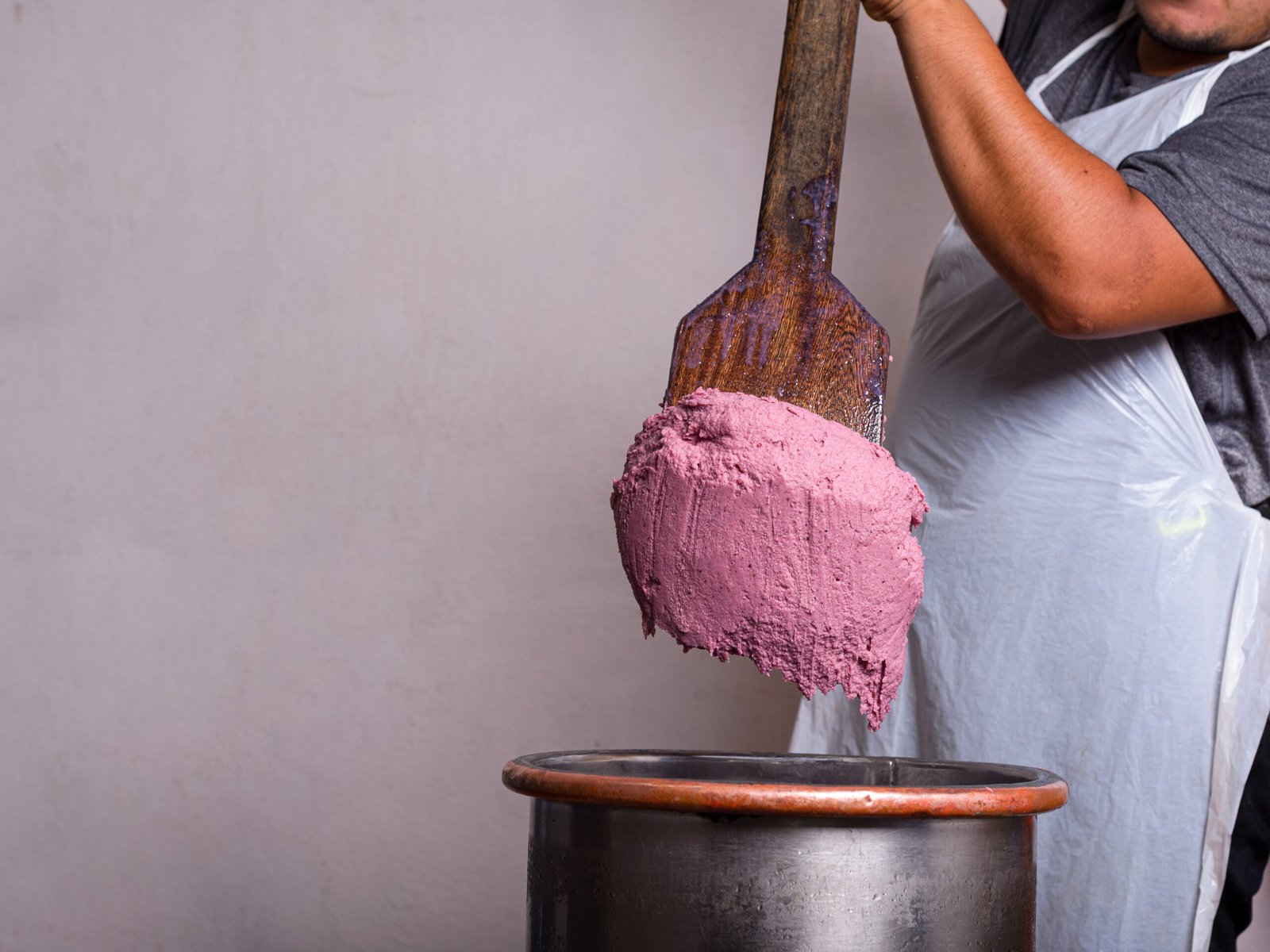 Craftsman using a large wooden paddle displays the ice cream he has made.